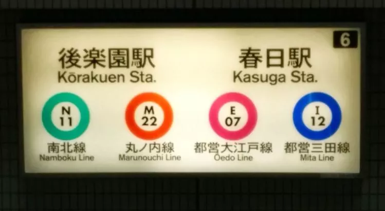 Streckenkennzeichnung an der Außenseite einer U-Bahn Station in Tokio