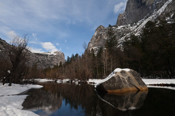 Der Mirror Lake spiegelt die schneebedeckte Landschaft aus Felsen und Bäumen